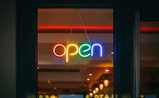 Leuchtendes, buntes Neonschild im Fenster „open“.
