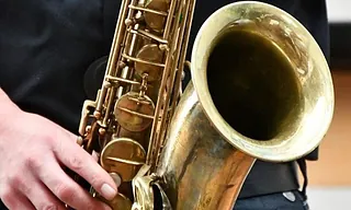 Nahaufnahme einer Hand, die ein Saxophon hält.